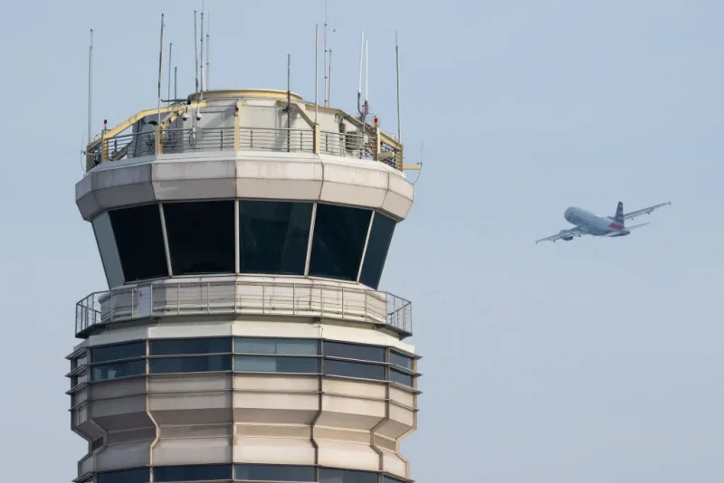 An American Airlines Airbus A319 airplane takes off past the air traffic control tower at Ronald Reagan Washington National Airport in Arlington, Virginia, January 11, 2023. The US Federal Aviation Authority said Wednesday that normal flight operations "are resuming gradually" across the country following an overnight systems outage that grounded departures. (Photo by SAUL LOEB / AFP) (Photo by SAUL LOEB/AFP via Getty Images)