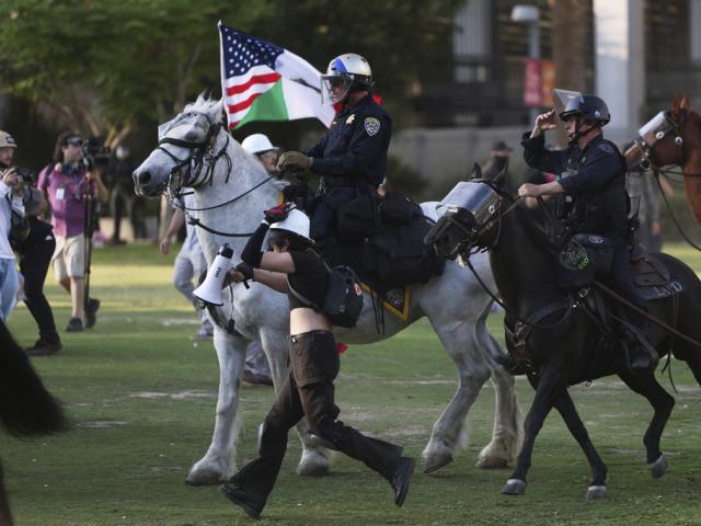 PHOTO: Los Angeles Metro police on horseback disperse protesters on Wednesday, June 11, 2025, in Los Angeles. (AP Photo/Ethan Swope)