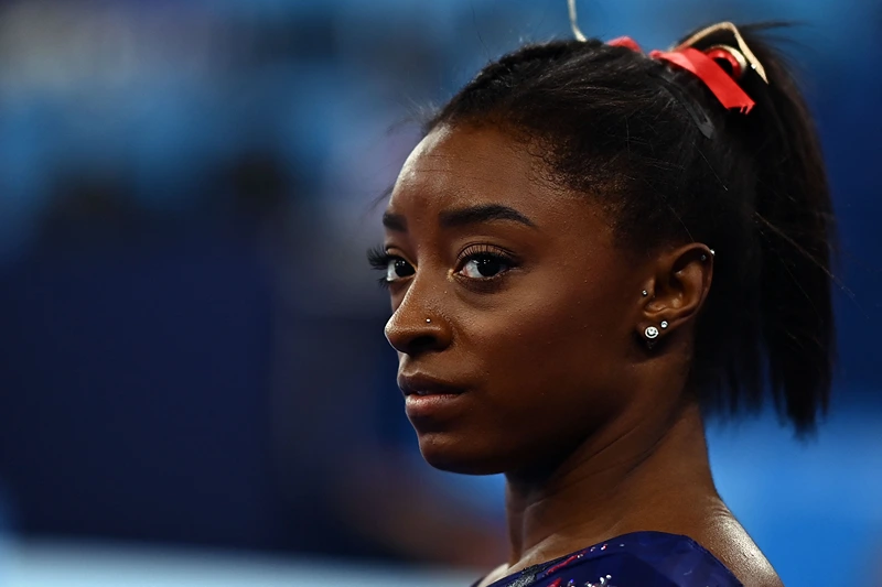 TOPSHOT - USA's Simone Biles gets ready to compete in the uneven bars event of the artistic gymnastics women's qualification during the Tokyo 2020 Olympic Games at the Ariake Gymnastics Centre in Tokyo on July 25, 2021. (Photo by Loic VENANCE / AFP) (Photo by LOIC VENANCE/AFP via Getty Images)