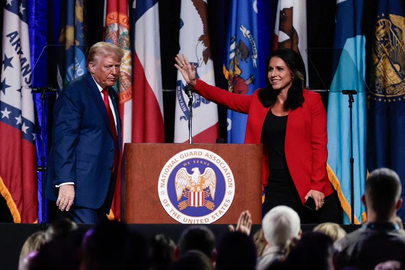 Former US Representative Tulsi Gabbard (R) waves after endorsing former US President and 2024 Republican presidential candidate Donald Trump (L) at the National Guard Association conference in Detroit, Michigan, on August 26, 2024. (Photo by JEFF KOWALSKY / AFP) (Photo by JEFF KOWALSKY/AFP via Getty Images)