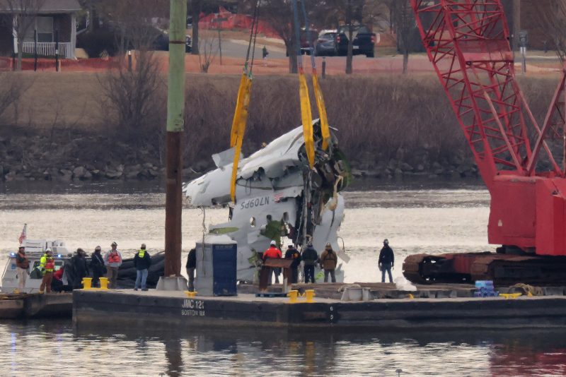 A large portion of the destroyed fuselage of American Airlines flight 5342 is lifted from the Potomac River during recovery efforts on February 03, 2025 in Arlington, Virginia. An American Airlines flight from Wichita, Kansas collided midair with a military Black Hawk helicopter while on approach to Ronald Reagan Washington National Airport on January 29, 2025 outside of Washington, DC. According to reports, there were no survivors among the 67 people onboard both aircraft. (Photo by Chip Somodevilla/Getty Images)