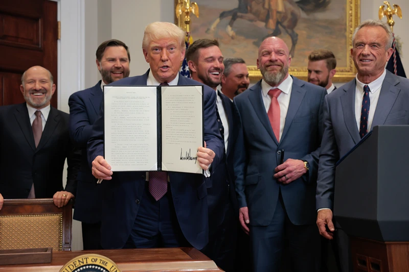 WASHINGTON, DC - JULY 31: U.S. President Donald Trump (C) displays a signed executive order during a signing ceremony in the Roosevelt Room of the White House on July 31, 2025 in Washington, DC. Standing with Trump are (L-R) Commerce Secretary Howard Lutnick, Vice President JD Vance, golfer Bryson DeChambeau, WWE Chief Creative Officer Paul “Triple H” Levesque, and US Secretary of Health and Human Services Robert F. Kennedy Jr. Trump signed a series of orders that will expand on his council on sports, fitness and nutrition, including by reviving the Presidential Fitness Test in public schools. (Photo by Anna Moneymaker/Getty Images)