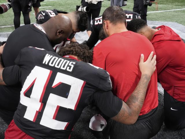 Atlanta Falcons players pray after their NFL preseason football game was suspended after Detroit Lions safety Morice Norris was injured Friday, Aug. 8, 2025, in Atlanta. (AP Photo/Brynn Anderson)