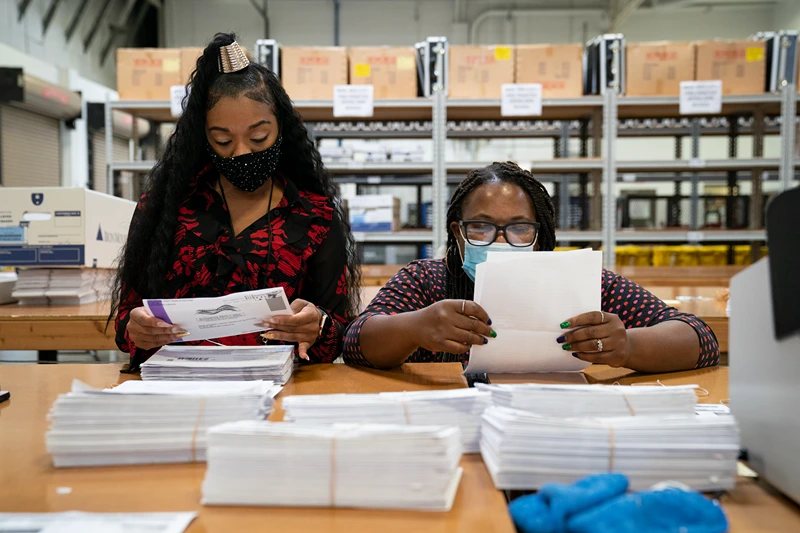 GLEN BURNIE, MD - OCTOBER 07: Working in bipartisan pairs, canvassers process mail-in ballots in a warehouse at the Anne Arundel County Board of Elections headquarters on October 7, 2020 in Glen Burnie, Maryland. The ballot canvas for mail-in and absentee ballots began on October 1st in Maryland, the earliest in the country. Every ballot goes through a five step process before being sliced open and tabulated. (Photo by Drew Angerer/Getty Images)