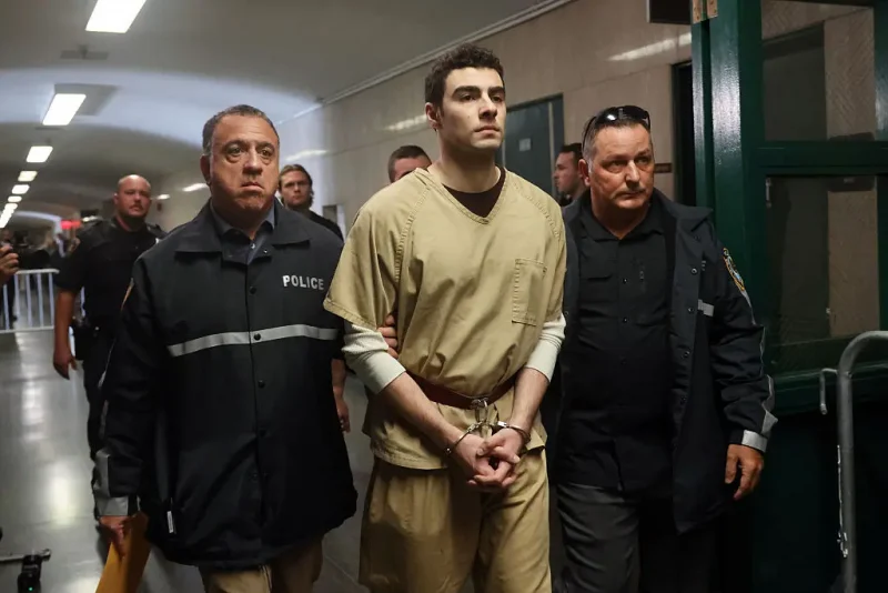 NEW YORK, NEW YORK - SEPTEMBER 16: Luigi Mangione is escorted by police as he arrives for a hearing as his lawyers push to have his state murder charges dismissed in the killing of UnitedHealthcare CEO Brian Thompson, at Manhattan Criminal Court on September 16, 2025 in New York City. Mangione is accused of murdering UnitedHealthcare CEO Brian Thompson late last year. He is facing 11 counts for the December 4th shooting outside a midtown Manhattan hotel, which set off a massive manhunt. He is also facing federal charges of murder and other charges in Pennsylvania, where he was arrested. (Photo by Spencer Platt/Getty Images)