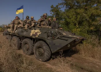 TOPSHOT - Ukrainian members of the OPFOR (opposing force) battalion ride on top of an armoured personnel carrier as they take part in a military training in the Donetsk region on September 26, 2023, amid the Russian invasion of Ukraine. (Photo by Roman PILIPEY / AFP) (Photo by ROMAN PILIPEY/AFP via Getty Images)