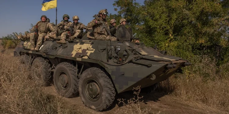 TOPSHOT - Ukrainian members of the OPFOR (opposing force) battalion ride on top of an armoured personnel carrier as they take part in a military training in the Donetsk region on September 26, 2023, amid the Russian invasion of Ukraine. (Photo by Roman PILIPEY / AFP) (Photo by ROMAN PILIPEY/AFP via Getty Images)