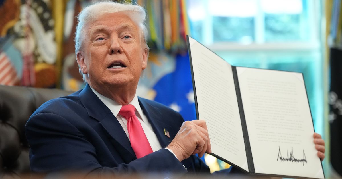 President Donald Trump holds up a proclamation with his signature in the Oval Office of the White House in Washington, D.C., on Aug. 14.