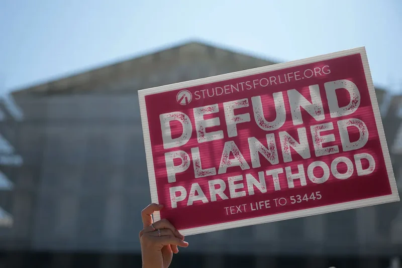 WASHINGTON, DC - JUNE 20: Protestors holding "Defund Planned Parenthood" signs stand outside of the U.S. Supreme Court on June 20, 2025 in Washington, DC. The Supreme Court began the morning with 16 cases to decide before the term ends and will end this week with 10 remaining. (Photo by Kayla Bartkowski/Getty Images)