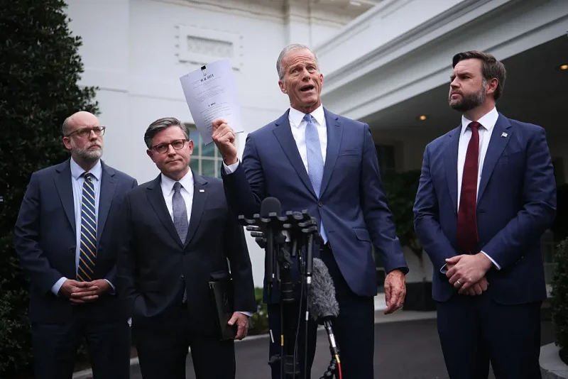 WASHINGTON, DC - SEPTEMBER 29: U.S. Senate Majority Leader John Thune (R-SD) delivers remarks and holds up a copy of a "clean CR" following a meeting with Congressional Democrats and U.S. President Donald Trump at the White House on September 29, 2025 in Washington, DC. Congressional leaders met with President Trump to negotiate funding legislation to avoid a government shutdown. Thune was accompanied by (L-R) Director of the Office of Management and Budget Russell Vought, Speaker of the House Mike Johnson (R-LA) and Vice President JD Vance. (Photo by Win McNamee/Getty Images)