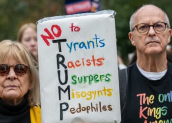 A crowd of mainly American anti-Trump protestors holds signs outside the U.S. Embassy in London during a "No Kings" protest against President Donald Trump on Oct. 18, 2025, in London, England.
