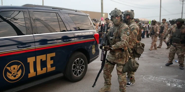 Immigration and Customs Enforcement (ICE) agents armed with less-lethal weapons gather outside an ICE processing center during a protest in Broadview, Illinois, on September 19, 2025. US President Donald Trump ordered increased federal law enforcement presence in Illinois and stepped-up immigration enforcement actions by the Department of Homeland Security. (Photo by OCTAVIO JONES / AFP) (Photo by OCTAVIO JONES/AFP via Getty Images)