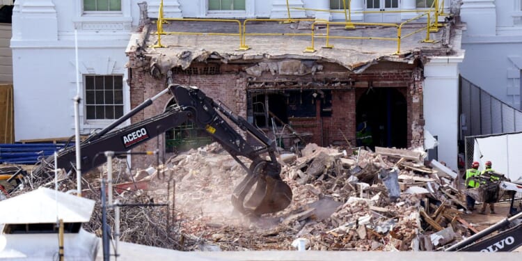 An excavator works to clear rubble after the East Wing of the White House was demolished on Thursday.