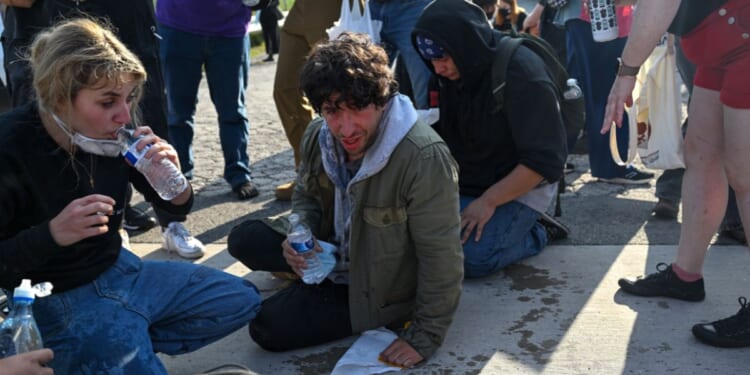 Demonstrators protesting outside the Immigration and Customs Enforcement facility, including Democratic congressional candidate Kat Abughazaleh, 26, react after being tear-gassed on Sept. 19, 2025, in Broadview, Illinois.