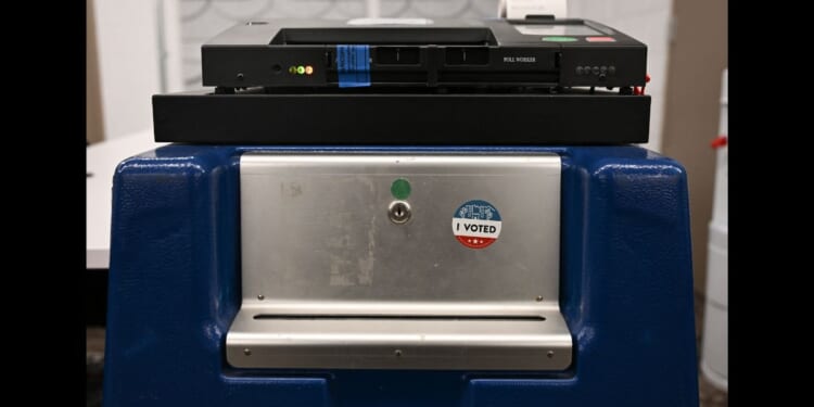 An "I Voted" sticker is displayed on the side of a box beneath a Dominion Voting Machines tabulator in Phoenix, Arizona, on June 3, 2024.