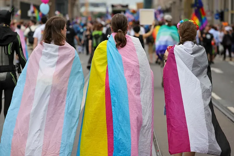 BERLIN, GERMANY - JULY 26: (L-R) Participants draped in the Transgender flag, Pan-sexual flag and asexual flag as the march during the 2025 Christopher Street Day CSD Berlin Pride march on July 26, 2025 in Berlin, Germany. The 47th Berlin CSD is taking place under the motto "Never be silent again!" (Photo by Omer Messinger/Getty Images)