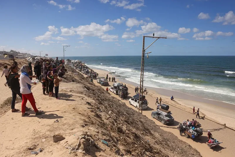 Palestinians carrying belongings arrive on a coastal path northwest of Nuseirat refugee camp as they are displaced southward from Wadi Gaza following an Israeli announcement of closing Al-Rashid road towards the north of the besieged Gaza Strip on October 1, 2025. Israel's defence minister issued a final warning for Gaza City residents to flee south on October 1, as the Palestinian Hamas movement weighed the latest US plan to end nearly two years of war in the Palestinian territory. (Photo by Bashar TALEB / AFP) (Photo by BASHAR TALEB/AFP via Getty Images)
