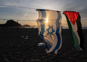 An Israeli and a Palestinian flag hang on an installation set up by members of the Brazilian NGO Rio de Paz at Copacabana beach in Rio de Janeiro, Brazil, on October 4, 2025, featuring photos of Israeli children killed in the bloody October 7, 2023, attack by Hamas on Israel, Palestinian children killed in Israeli bombardments of the Gaza Strip in retaliation, and Brazilian children killed by stray bullets during police operations. The demonstration, featuring 200 photos of Israeli, Palestinian and Brazilian children, denounced the violence that cuts lives short and steals childhoods. (Photo by Pablo PORCIUNCULA / AFP) (Photo by PABLO PORCIUNCULA/AFP via Getty Images)
