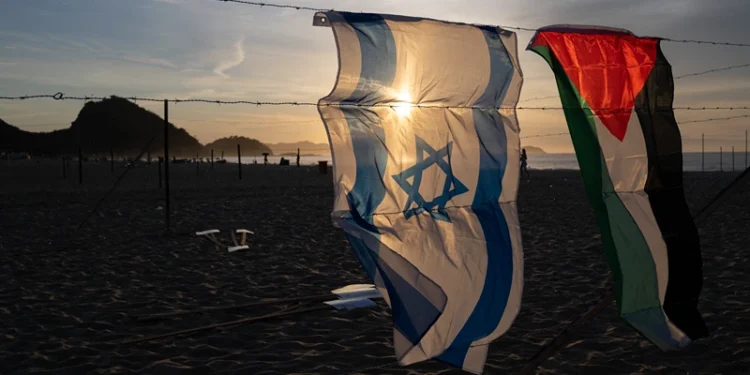 An Israeli and a Palestinian flag hang on an installation set up by members of the Brazilian NGO Rio de Paz at Copacabana beach in Rio de Janeiro, Brazil, on October 4, 2025, featuring photos of Israeli children killed in the bloody October 7, 2023, attack by Hamas on Israel, Palestinian children killed in Israeli bombardments of the Gaza Strip in retaliation, and Brazilian children killed by stray bullets during police operations. The demonstration, featuring 200 photos of Israeli, Palestinian and Brazilian children, denounced the violence that cuts lives short and steals childhoods. (Photo by Pablo PORCIUNCULA / AFP) (Photo by PABLO PORCIUNCULA/AFP via Getty Images)