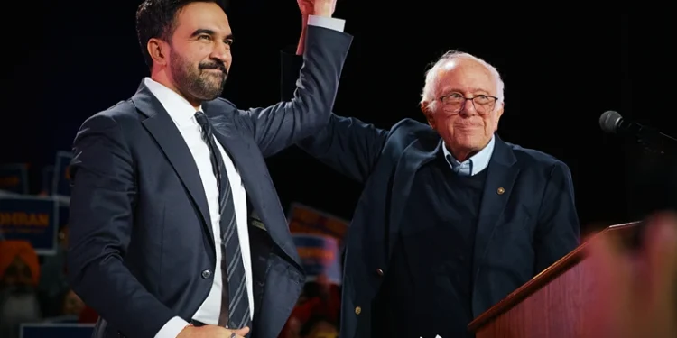 NEW YORK, NEW YORK - OCTOBER 26: New York Mayoral Candidate Zohran Mamdani celebrates with Sen. Bernie Sanders (I-VT) during an election rally with Sanders and U.S. Rep. Alexandria Ocasio-Cortez (D-NY) at Forest Hills Stadium on October 26, 2025 in the Queens borough of New York City. The mayoral election will take place on November 4, 2025. (Photo by Andres Kudacki/Getty Images)