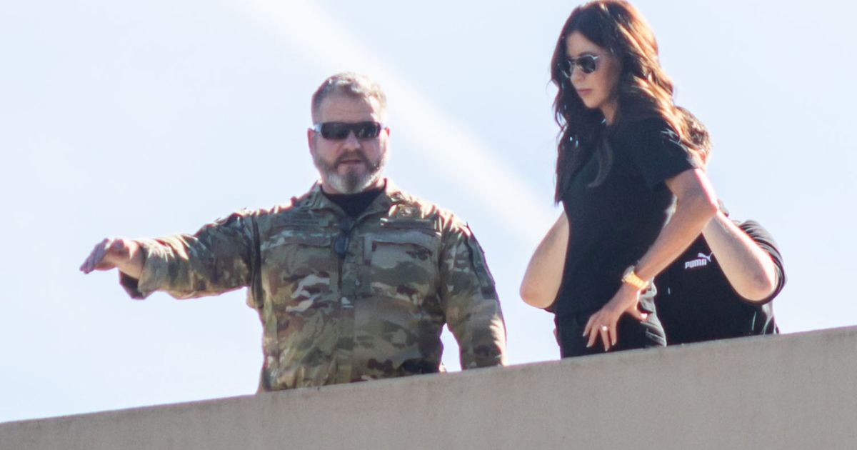 Secretary of Homeland Security Kristi Noem, right, stands on the roof of a U.S. Immigration and Customs Enforcement facility in Portland, Oregon, on Tuesday.