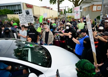 PORTLAND, OREGON - SEPTEMBER 28: Protesters engage a vehicle that drove into the crowd outside of the U.S. Immigration and Customs Enforcement building on September 28, 2025 in Portland, Oregon. In a Truth Social post on September 27th, President Trump authorized the deployment of military troops to "protect War ravaged Portland, and any of our ICE Facilities under siege from attack by Antifa, and other domestic terrorists." (Photo by Mathieu Lewis-Rolland/Getty Images)