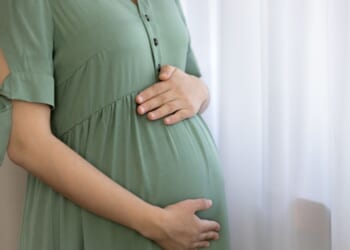 A pregnant woman holds her belly and prepares for childbirth.