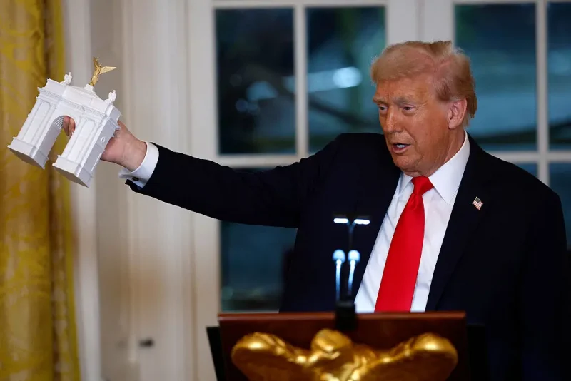 WASHINGTON, DC - OCTOBER 15: U.S. President Donald Trump holds a model of an arch as he delivers remarks during a ballroom fundraising dinner in the East Room of the White House on October 15, 2025 in Washington, DC. Trump hosted organizations and individuals for a fundraising dinner for the new $250 million ballroom addition currently under construction at the White House. (Photo by Kevin Dietsch/Getty Images)