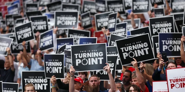 GLENDALE, ARIZONA - SEPTEMBER 21: Attendees hold up Turning Point USA signs at the memorial service for political activist Charlie Kirk at State Farm Stadium on September 21, 2025 in Glendale, Arizona. Kirk, the CEO and co-founder of Turning Point USA, was shot and killed on September 10th while speaking at an event during his "American Comeback Tour" at Utah Valley University. (Photo by Eric Thayer/Getty Images)