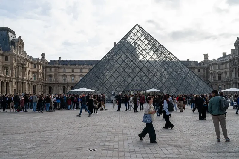 The Cour Napoleon with the Louvre Pyramid in the center of the courtyard, several visitors queue to enter the Louvre Museum upon its reopening after the burglary of several jewels on October 19 in Paris, France, October 22, 2025. The Louvre Museum reopened its doors on October 22 after three days of closure, following the burglary of which it was the victim. The museum reopens its doors this Wednesday, with the exception of the Apollo Gallery. (Photo by Riccardo Milani / Hans Lucas via AFP) (Photo by RICCARDO MILANI/Hans Lucas/AFP via Getty Images)