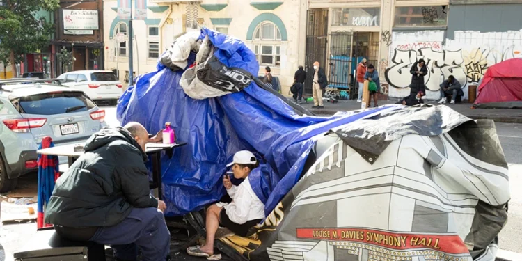 People and their belongings are seen on Jones Street in San Francisco, on November 13, 2023. San Francisco has struggled to clean up the city ahead of hosting world and business leaders. (Photo by Jason Henry / AFP) (Photo by JASON HENRY/AFP via Getty Images)