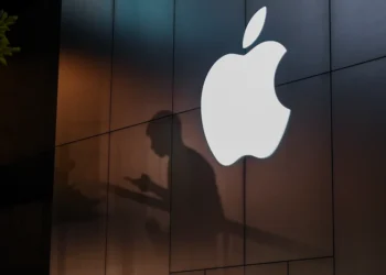 The shadow of a man is cast on the wall of an Apple store as he uses his mobile phone in Beijing on August 26, 2019. There were signs of a thaw in frosty trade-war tensions between China and the US on August 26 as President Donald Trump said delegations would "very shortly" resume talks and Beijing