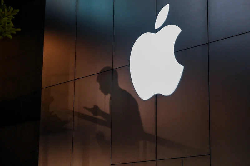 The shadow of a man is cast on the wall of an Apple store as he uses his mobile phone in Beijing on August 26, 2019. There were signs of a thaw in frosty trade-war tensions between China and the US on August 26 as President Donald Trump said delegations would "very shortly" resume talks and Beijing