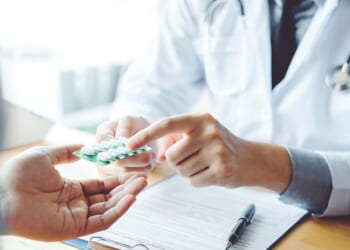 Doctor showing prescription drug to patient