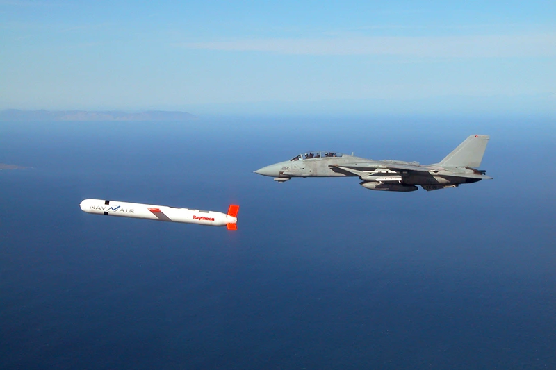 A Tactical "Tomahawk" Block IV cruise missile is escorted by a Navy F-14 "Tomcat" fighter during a controlled test over the Naval Air Systems Command (NAVAIR) western test range complex in southern California. The Tactical Tomahawk, scheduled to join the fleet in 2004, is the next generation of Tomahawk cruise missile and it adds the capability to reprogram the missile while in-flight to strike any of 15 preprogrammed alternate targets or redirect the missile to any Global Positioning System (GPS) target coordinates. Warplanes from a US-British coalition bombed communications facilities in the south of the country after an Iraqi military jet violated the no-fly zone, the US military said 22 November. AFP PHOTO/US NAVY HO (Photo by US NAVY / AFP) (Photo by -/US NAVY/AFP via Getty Images)