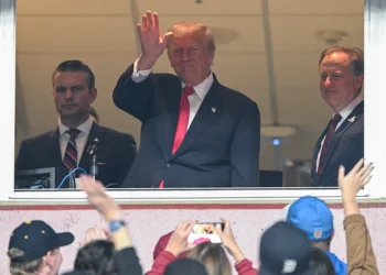 LANDOVER, MARYLAND - NOVEMBER 9: Secretary of War Pete Hegseth (L) and Commanders team owner Josh Harris (R) watch U.S. President Donald Trump greet fans as he attends the NFL football game between the Detroit Lions and Washington Commanders at Northwest Stadium on November 9, 2025 in Landover, Maryland. Trump attended the game to honor military veterans during halftime of the game. (Photo by John McDonnell/Getty Images)