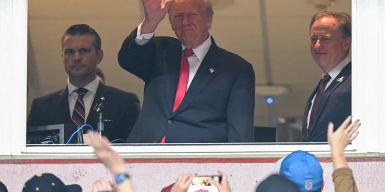 LANDOVER, MARYLAND - NOVEMBER 9: Secretary of War Pete Hegseth (L) and Commanders team owner Josh Harris (R) watch U.S. President Donald Trump greet fans as he attends the NFL football game between the Detroit Lions and Washington Commanders at Northwest Stadium on November 9, 2025 in Landover, Maryland. Trump attended the game to honor military veterans during halftime of the game. (Photo by John McDonnell/Getty Images)