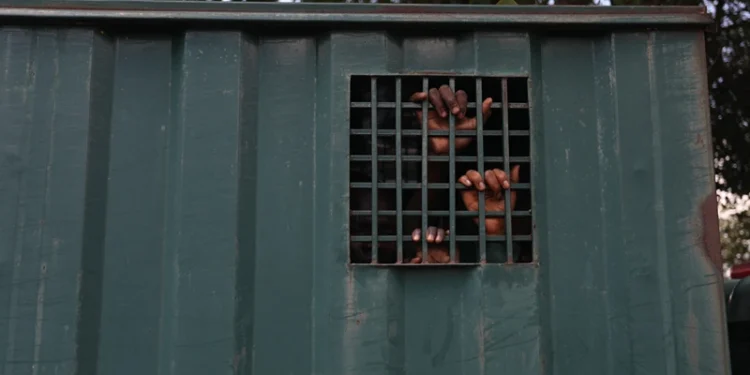 TOPSHOT - The hands of recaptured inmates are seen inside a prison vehicle in Abuja, Nigeria on July 6, 2022, after suspected Boko Haram gunmen attacked the Kuje Medium Prison. Suspected Boko Haram gunmen used explosives to blast their way into a Nigerian prison near the capital, freeing hundreds of inmates in a raid to break out jailed jihadists, the government said on Monday. The brazen attack on the outskirts of Abuja came hours after an ambush on a presidential security convoy in the northwest, in a fresh illustration of Nigeria