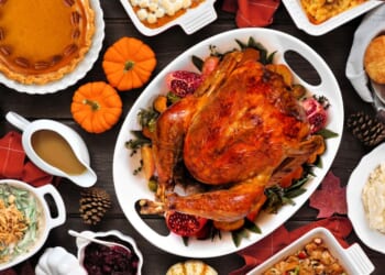 A traditional turkey Thanksgiving dinner is set up on a table.