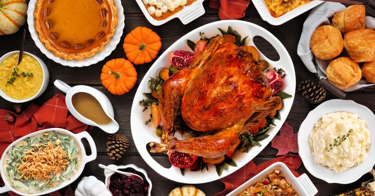 A traditional turkey Thanksgiving dinner is set up on a table.