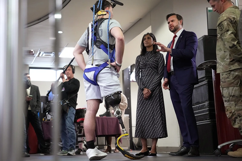 US Vice President JD Vance (2R) and second lady Usha Vance talk with Coast Guard Seaman Sam Kenyon as he undergoes therapy as they visit the Military Advanced Training Center (MATC) at Walter Reed National Military Medical Center on November 10, 2025 in Bethesda, Maryland. Vance met with members of the military the day before Veterans Day, the nation's holiday to honor those who have served in the military. (Photo by Andrew Harnik / POOL / AFP) (Photo by ANDREW HARNIK/POOL/AFP via Getty Images)