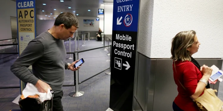 MIAMI, FL - MARCH 04: A sign points passengers to the mobile passport control window set up for international travelers arriving at Miami International Airport on March 4, 2015 in Miami, Florida. Miami-Dade Aviation Department and U.S. Customs and Border Protection (CBP) unveiled a new mobile app for expedited passport and customs screening. The app for iOS and Android devices allows U.S. citizens and some Canadian citizens to enter and submit their passport and customs declaration information using their smartphone or tablet and to help avoid the long waits in the exit lanes. (Photo by Joe Raedle/Getty Images)