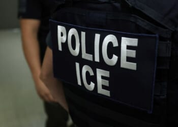 An Immigration and Customs Enforcement (ICE) agent stands in a hallway outside of a courtroom in the New York Federal Plaza Immigration Court in New York on July 17, 2025.