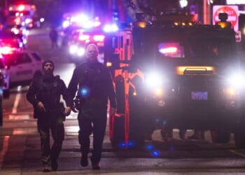 Police officers remain on the scene of a shooting that killed two and wounded at least eight at Brown University on Dec. 13, 2025, in Providence, Rhode Island.