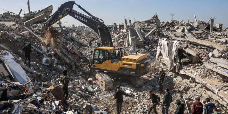 Palestinian Hamas militants and Egyptian workers accompanied by members of the International Committee of the Red Cross use a digger as they search for the last two remaining bodies of hostages, an Israeli soldier and a Thai national, under the rubble of the Jabalia refugee camp, in the northern of Gaza Strip on Dec. 1, 2025.