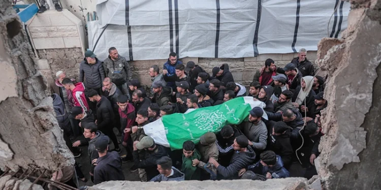 Mourners carry the body of Raid Saad, a commander of the Al-Qassam Brigades, during his funeral in the Al-Shati refugee camp in Gaza City, Gaza on December 14, 2025. Saad was killed in an Israeli airstrike that targeted a car west of Gaza City, according to Hamas. The strike occurred amid a ceasefire between Israel and Hamas. (Photo by Abood Abusalama / Middle East Images / AFP via Getty Images)