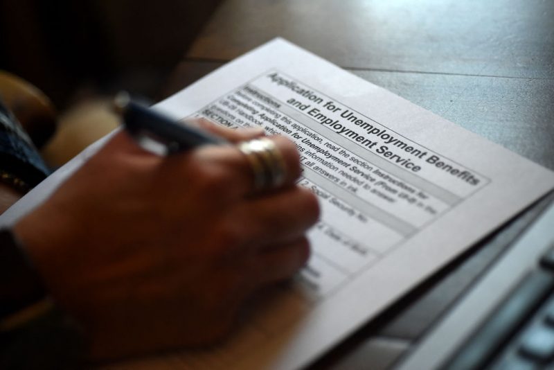 In this photo illustration, a person files an application for unemployment benefits on April 16, 2020, in Arlington, Virginia. The government reported Thursday that another 5.2 million US workers filed for unemployment benefits, taking the four-week total to 22 million, a staggering figure in a downturn that economists say presents the country with its most severe outlook since the Great Depression of the 1930s. (Photo by Olivier DOULIERY / AFP) (Photo by OLIVIER DOULIERY/AFP via Getty Images)