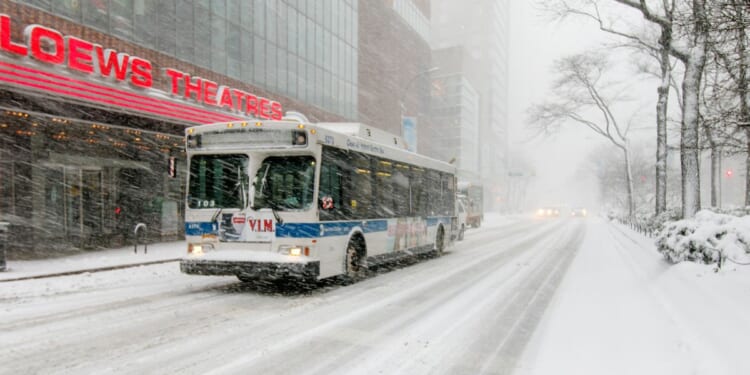 A bus drives through the winter on Broadway near 68th street in New York City during a snowfall on Feb. 9, 2017.