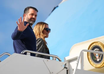 LOSSIEMOUTH, SCOTLAND - JULY 29: Donald Trump Jr. with partner Bettina Anderson prepare to board Air Force One at RAF Lossiemouth, on July 29, 2025 in Lossiemouth, Scotland. President Trump visited Scotland on a trip that was part-vacation, part-work, as he stayed at his Trump Turnberry golf course, followed by the Trump International Golf Links in Aberdeenshire, between July 25 to 29. (Photo by Andrew Harnik/Getty Images)