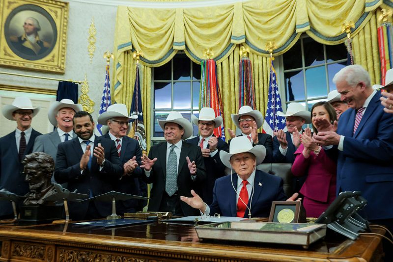 WASHINGTON, DC - DECEMBER 12: U.S. President Donald Trump puts on a hat given to him by the 1980 U.S. Olympic men’s ice hockey team as Trump honors the team in the Oval Office of the White House on December 13, 2025 in Washington, DC. Trump honored the ‘Miracle on Ice’ team, who defeated the Soviet Union and went on to win the 1980 Gold medal in Ice Hockey, by signing a bill to award the players congressional gold medals. (Photo by Anna Moneymaker/Getty Images)